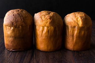 Panettone Breads on Dark Wooden Surface.
