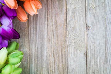 Spring and Easter background with tulips on wooden board, flat lay