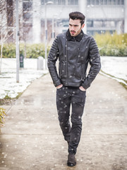 Fototapeta na wymiar Handsome young man standing outside in winter, in snowy Turim, in Italy