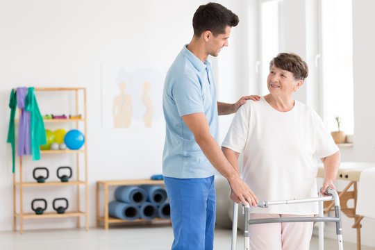 Elderly woman and caring physiotherapist