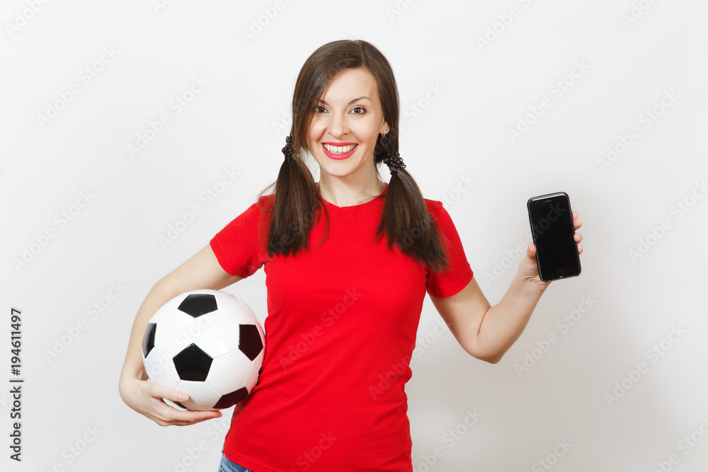 Wall mural European young woman, two fun pony tails, football fan or player in red uniform hold soccer ball, mobile phone isolated on white background. Sport play football, healthy lifestyle concept. Copy space.