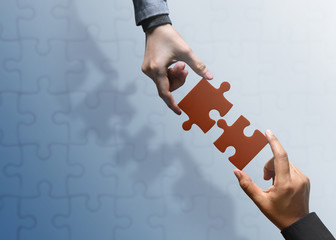 Business Partnership or Teamwork Concept. Hands of two People Try to Fit or Conncet Jigsaw Puzzle...