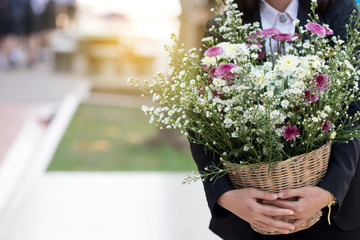 Woman carrying a bouquet of flowers.