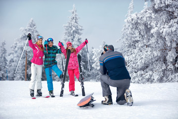father taking picture of family on snow.outdoor in sunny day.