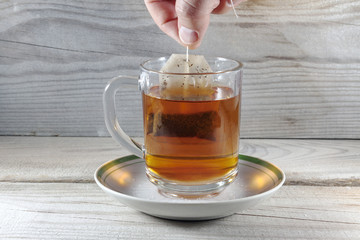 A mug with a spoon and a bag of tea is filled with boiling water