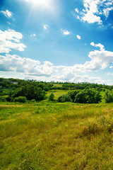 Fototapeta na wymiar a summer landscape of rolling hills with beautiful clouds