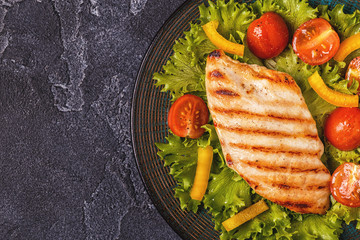 Grilled chicken breast served with vegetable salad.