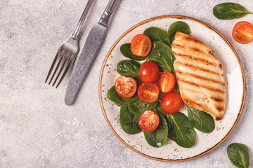Grilled chicken breast served with vegetable salad.