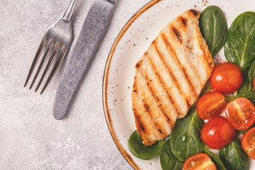 Grilled chicken breast served with vegetable salad.