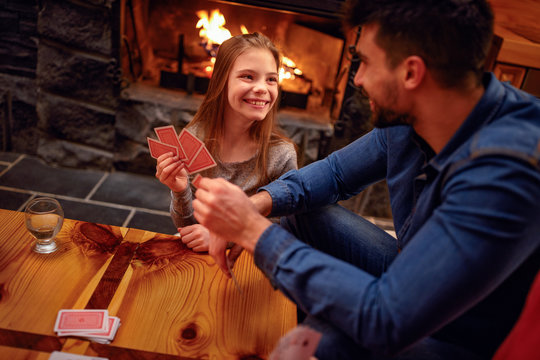 Smiling father and daughter have great time playing card