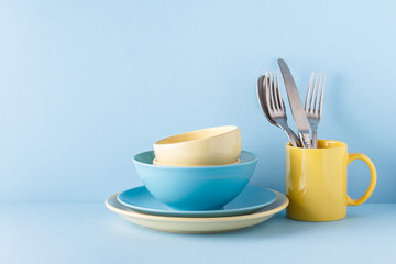 Fototapeta na wymiar Crockery and cutlery on a blue pastel background
