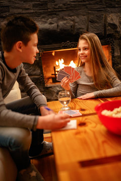 brother and sister having fun playing card game at home
