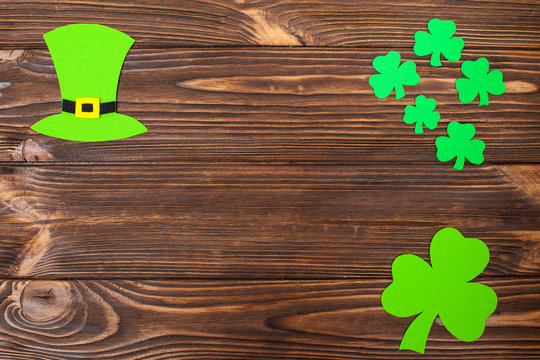 St. Patrick's Day theme colorful horizontal banner. Green leprechaun hat and shamrock leaves on brown wooden background. Felt craft elements. Copy space. For greeting card,congratulation banner