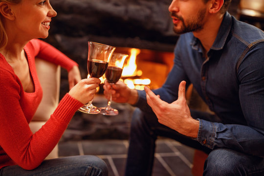 Romantic couple in love enjoying in wine near fireplace