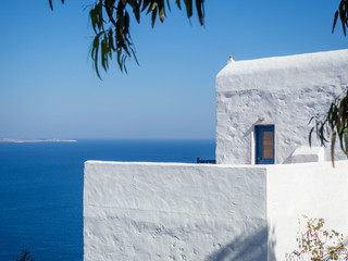A blue traditional window and a balcony looking over the aegean