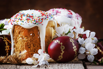 Easter cake and red painted eggs, white apricot flowers, festive composition in rustic style, russian orthodox tradition, vintage wooden background, selective focus