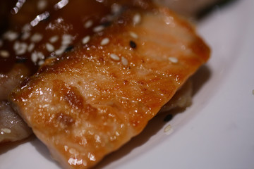 Fish meat fried in caramel sauce with sesame on plate