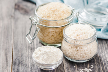 Rice and flour in jars on wooden background. Selective focus, space for text. 