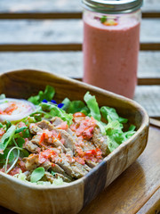 Grill pork slice mixed with vegetable, chili, lemon in wood bowl on wood table