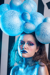 Young attractive girl in makeup, in glasses and balloons on the head