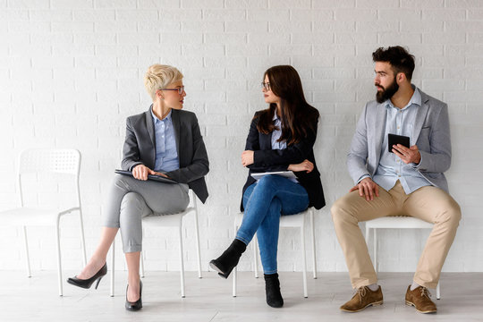Young cheerful business people waiting for job interview 
