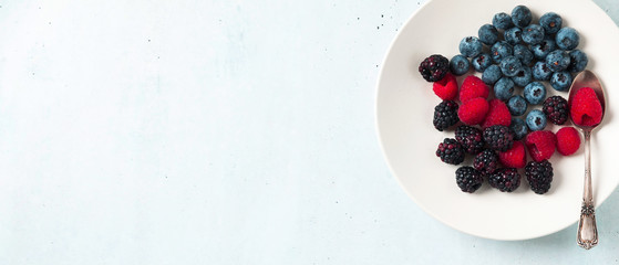 Fruit salad with Various fresh summer berries in white plate . Top view