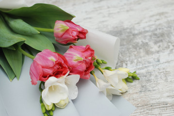 Beautiful bouquet of pink tulips and Freisia Flowers on wooden background. Spring bouquet for Gift with Copy Space.