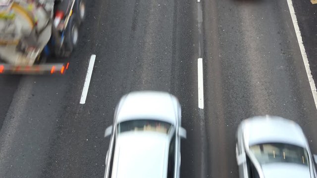 Overhead point of view of cars and vans driving on three lane road, blurred
