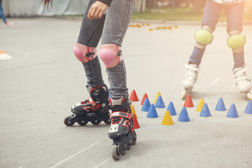 Legs of person on inline rollerblades. Rollerblader and slalom cone. Kid's legs.