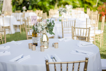 Gold and White Table Decor with Bouquet of Flowers and Wine Bottle Table Number Sign