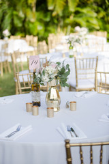 Gold and White Table Decor with Bouquet of Flowers and Wine Bottle Table Number Sign