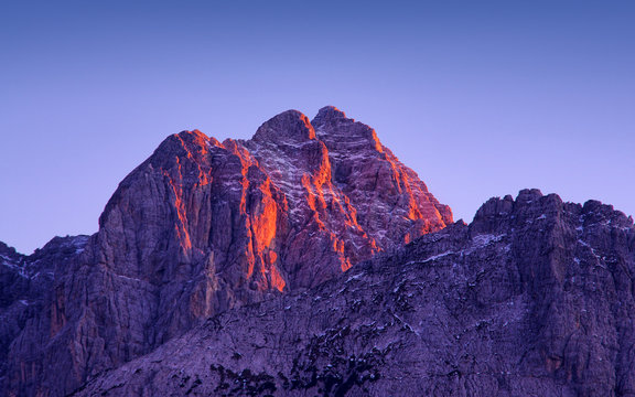 sunset light on Jof Fuart peak from Valbruna town. Julien Alps, Italy