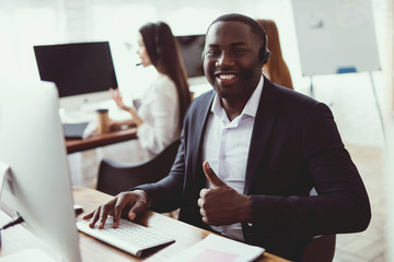 A black guy poses on the camera in the call center.