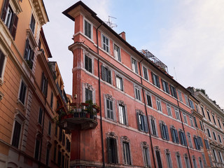 Naklejka premium Old narrow dirty pink residential building with round balcony. Rome, Italy