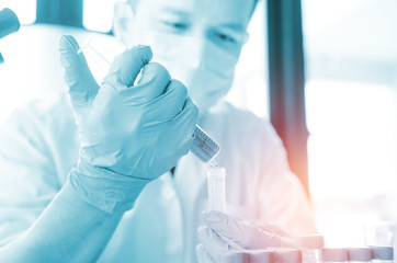 closeup hand of scientist in lab . Hand hold syringe  blood in tube , Testing result  Medical or chemical background