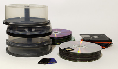 data storages of all nowadays: stack of floppy disks, stack of compact discs and empty tube cake...
