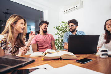 Group of multi ethnic young students preparing for exams in home interior.
