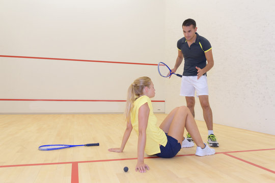 couple in squash court woman sat on floor