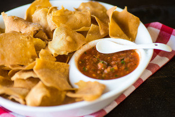 Spicy red salsa with a plate of tortilla chips