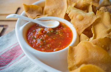 Spicy red salsa with a plate of tortilla chips