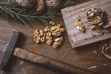 Cracked walnuts with hammer on the board