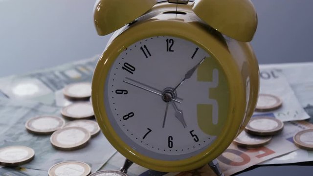 Alarm clock on coins and banknotes