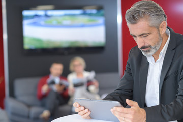 smiling businessman using a tablet outside the cafe