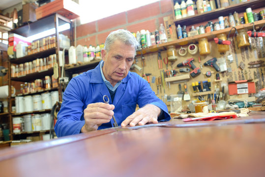 a portrait of mature handyman at diy workshop
