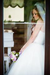 Beautiful smiling bride behind the glass