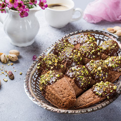 Homemade chocolate cookies Madeleine with chopped pistachio nuts in metal basket. Holidays and party food concept with copy space.