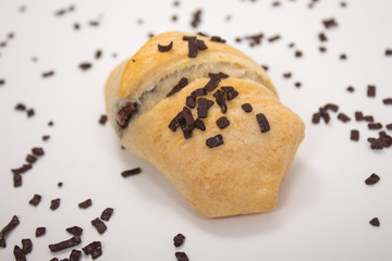 Fototapeta na wymiar kleines Schokoladen Croissant mit Schokoladenstreuseln vor weißem Hintergrund