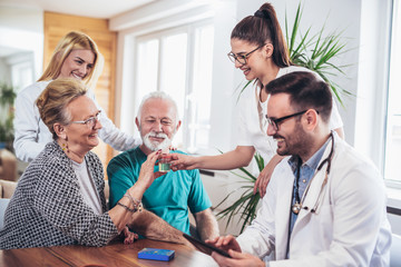 Senior Couple In Discussion With Health Visitor At Home. They talk about prescribed therapy and...
