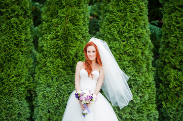 Bride with flowers in hand outdoors in summer or winter. The bride is nervous before the wedding....
