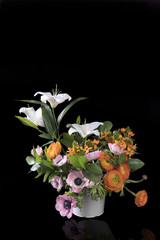 wedding bouquet of buttercups, anemones and Ruscus on the black background